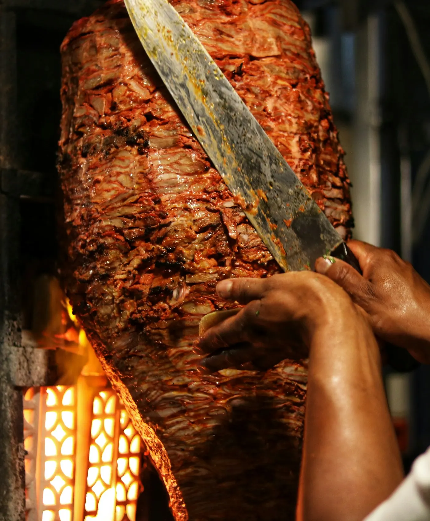 Ustanın bıçağıyla dilimlenen, kızarmış yüzeyli et döner
